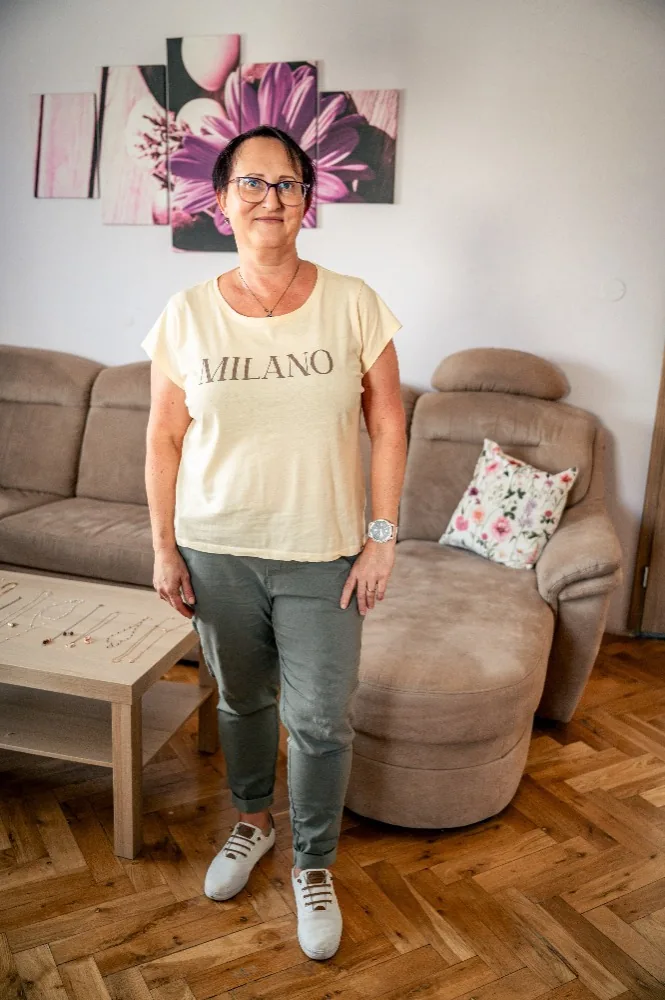Klientka před osobním stylingem v béžovém tričku, khaki kalhotách a bílých teniskách
