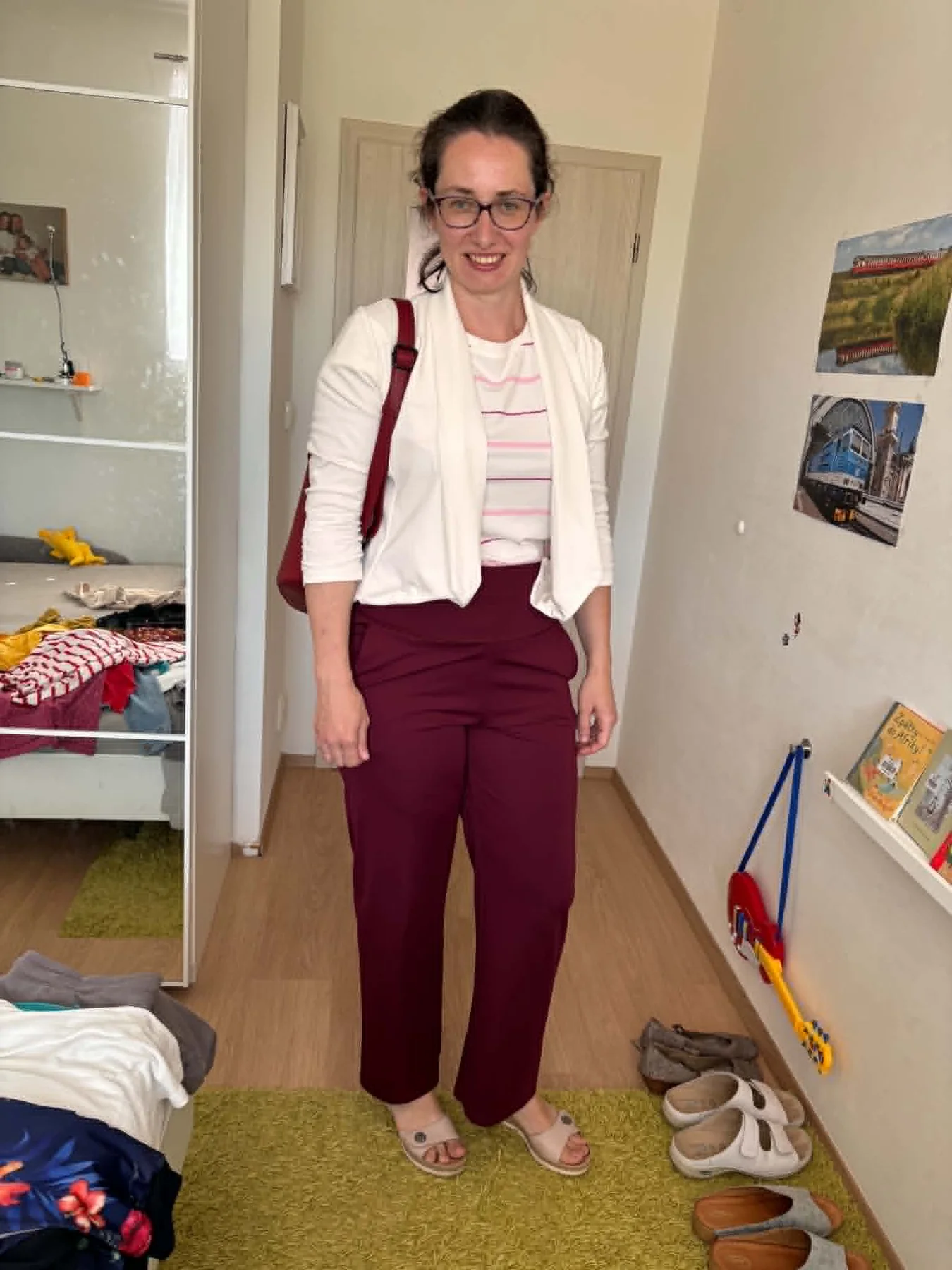 Ukázka outfitu po třídění šatníku – bílé sako, pruhované tričko a vínové kalhoty.